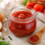 Domowy ketchup z pomidorów w szklanym słoiku