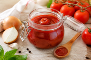 Domowy ketchup z pomidorów w szklanym słoiku